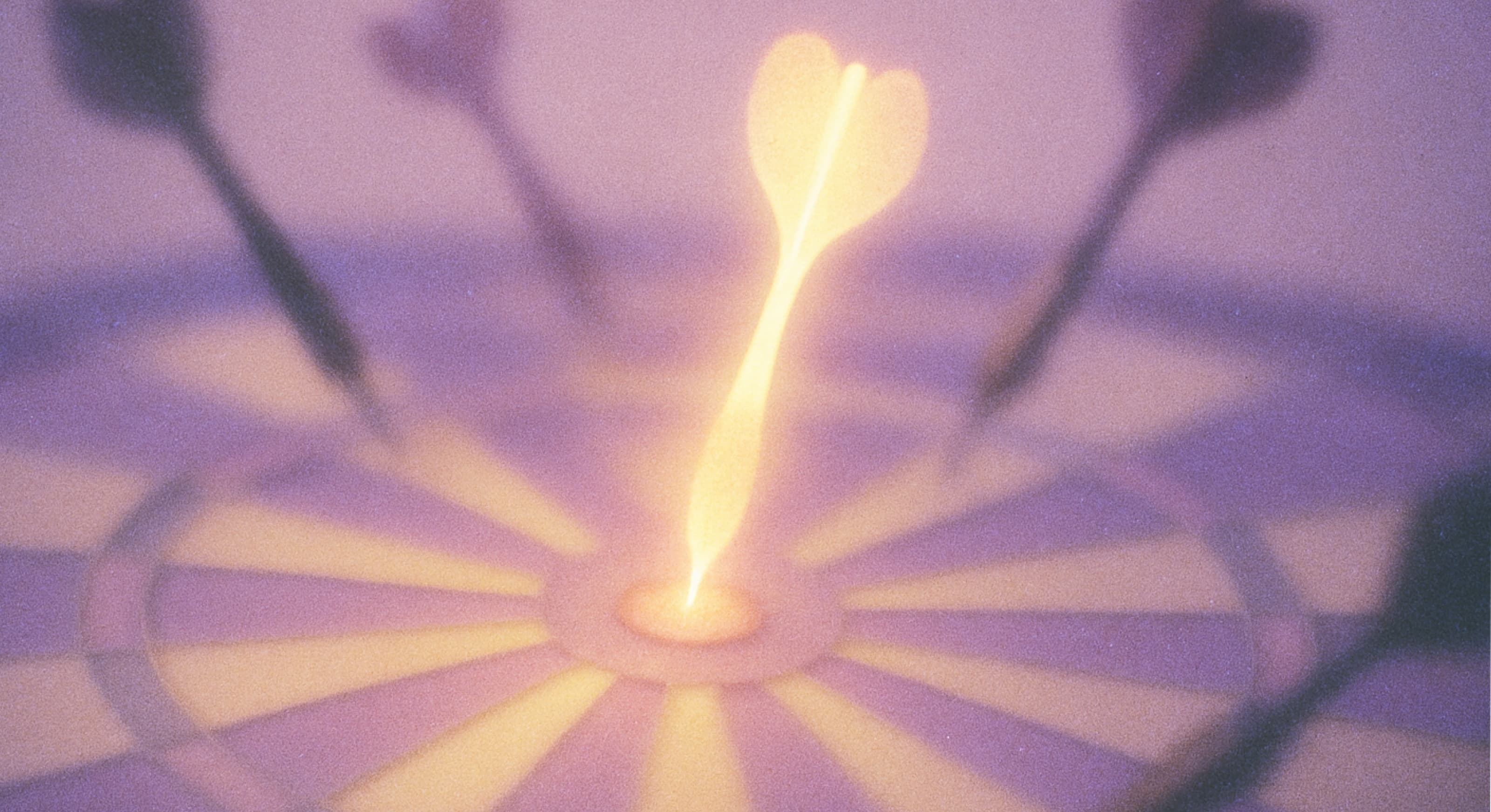 A dartboard with a glowing dart hitting the bullseye, surrounded by blurred darts, in a soft purple and pink lighting.
